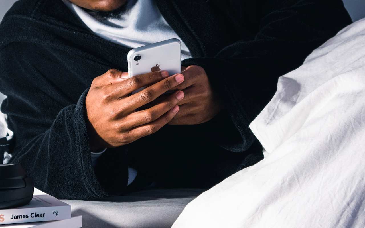Persona mirando el móvil en la cama - Unsplash