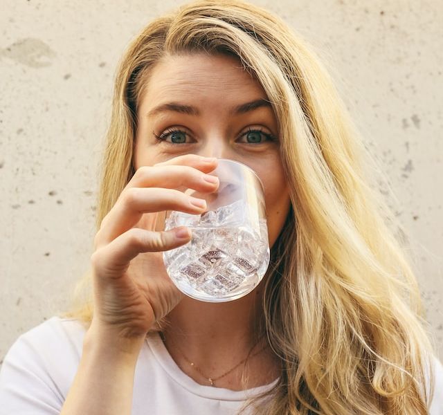 Mujer bebiendo agua - Unsplash